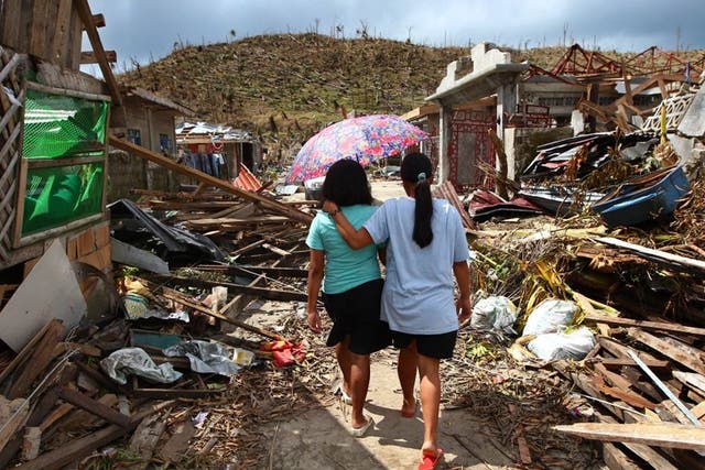 Typhoon Haiyan survivors walk amid ruins of buildings in Maraboth, Philippines