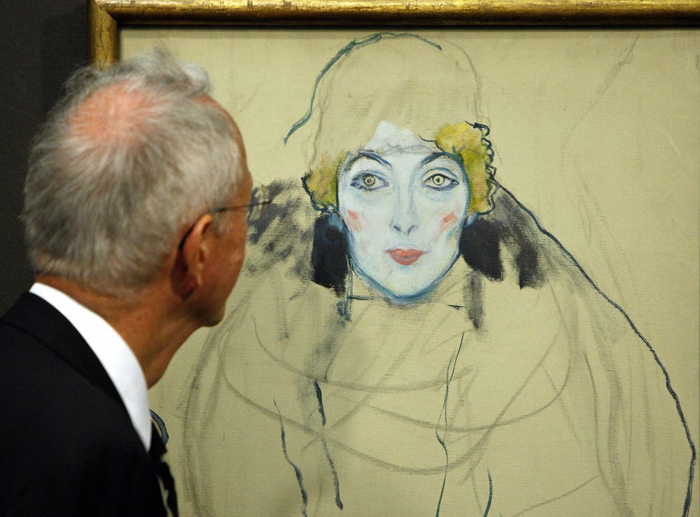 A visitor looks at an unfinished painting entitled 'Portrait of a Woman's Face' by Austrian artist Gustav Klimt 