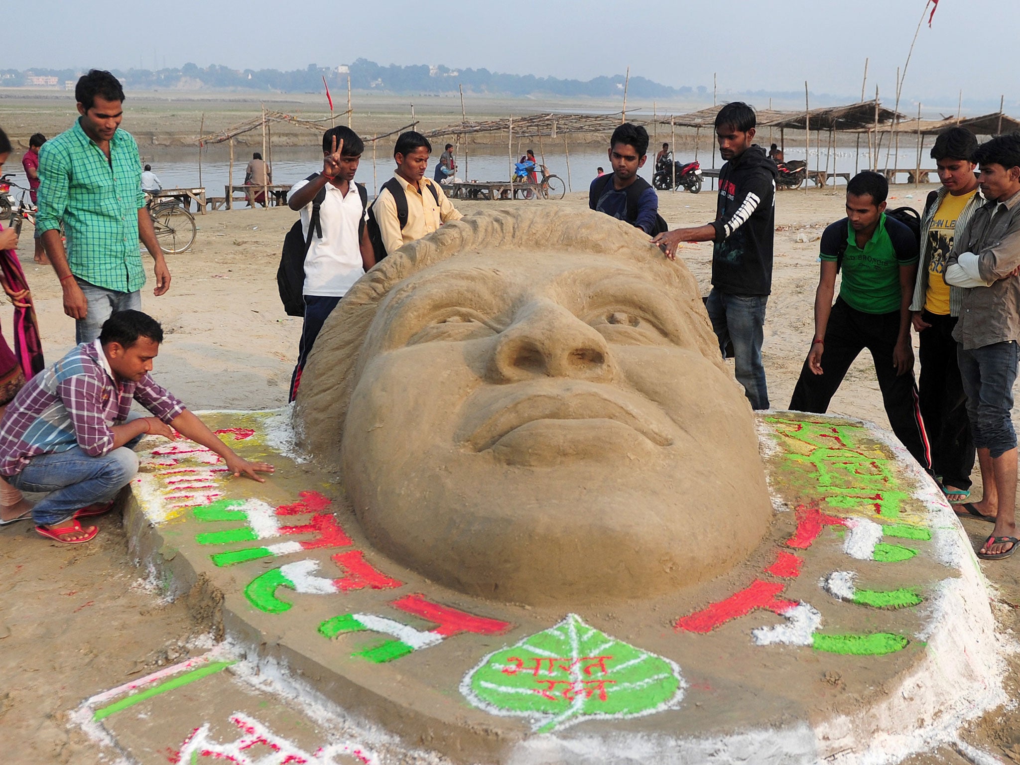 University students carve an image of Sachin Tendulkar in the sand in tribute to the retiring cricketer