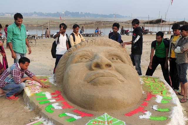 University students carve an image of Sachin Tendulkar in the sand in tribute to the retiring cricketer
