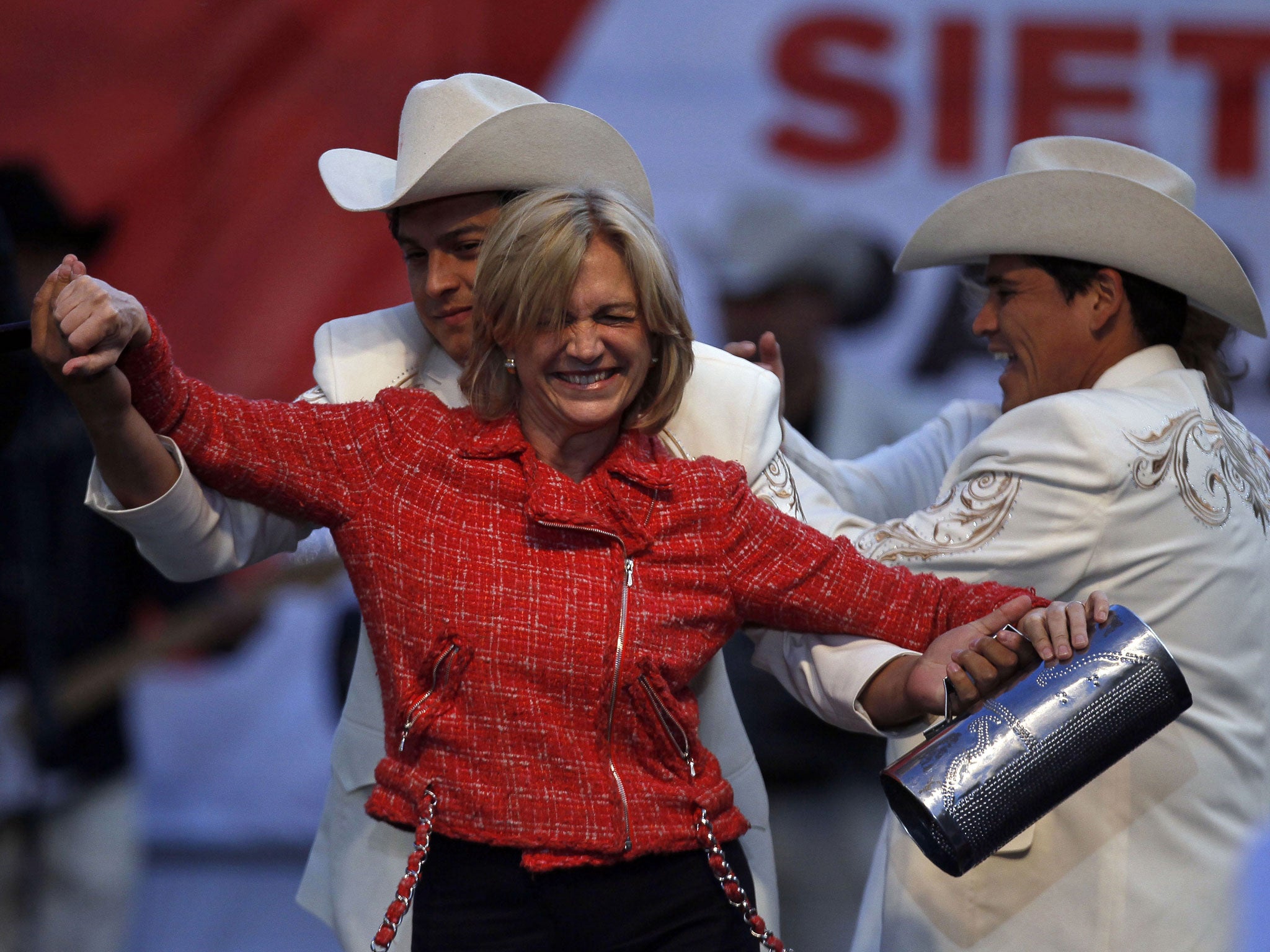 Evelyn Matthei dances with musicians at a closing campaign rally in Chillan, Chile