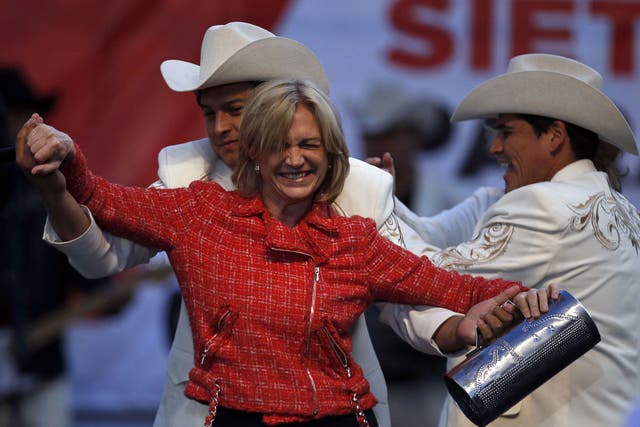 Evelyn Matthei dances with musicians at a closing campaign rally in Chillan, Chile 