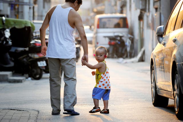 A family make their way along a lane in Beijing 