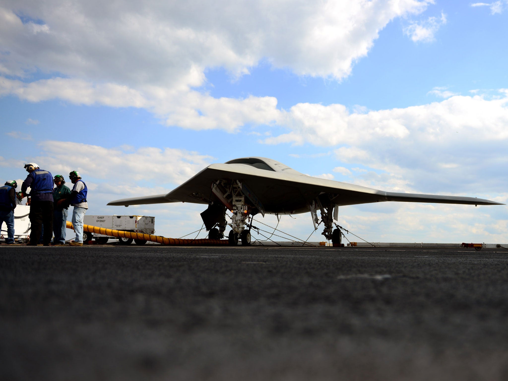 Northrop Grumman personnel conduct pre-operational tests on an X-47B Unmanned Combat Air System (UCAS) demonstrator on the flight deck of the aircraft carrier USS George H.W. Bush