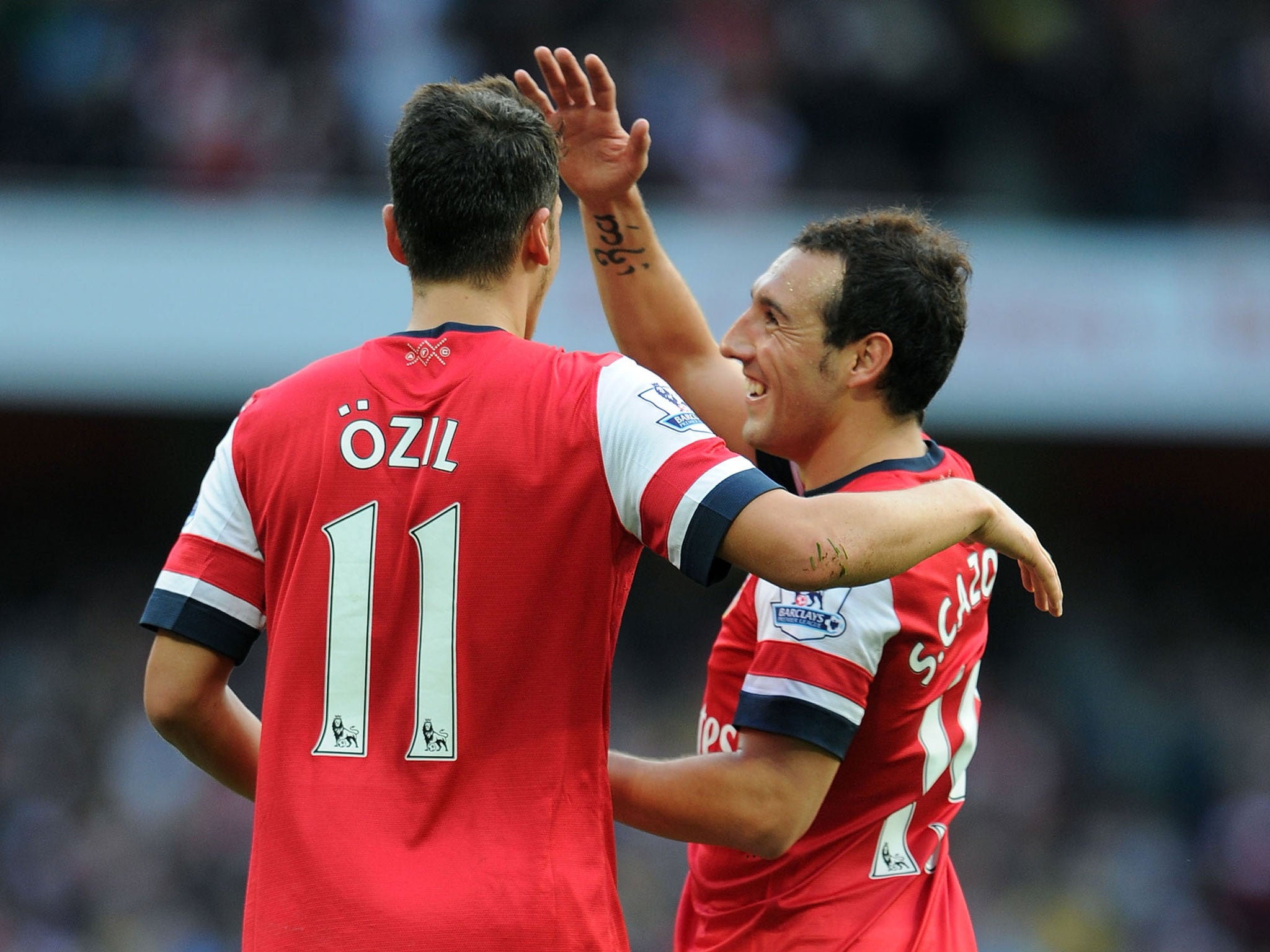 Mesut Ozil celebrates his second goal for Arsenal against Norwich City last month with Santi Cazorla