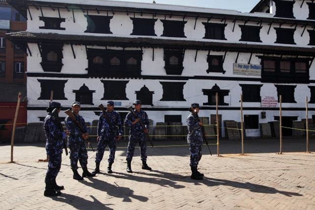 Nepalese policemen stand guard at a temporary polling booth space set by ropes and polls in Katmandu