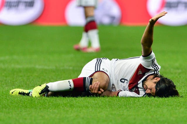 Sami Khedira of Germany calls for assistance after sustaining an injury against Italy
