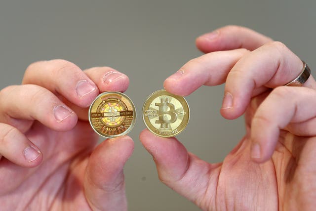 Software engineer Mike Caldwell shows the front (R) and back, hologram side, (L) of a physical Bitcoin he minted in his shop on April 26, 2013 in Sandy.