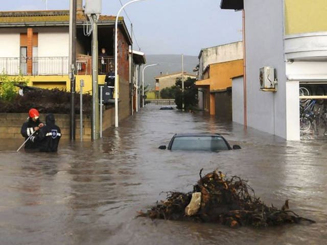 Rescuers work in a flooded street in the small town of Uras, Sardinia, Monday, 18 Nov, 2013