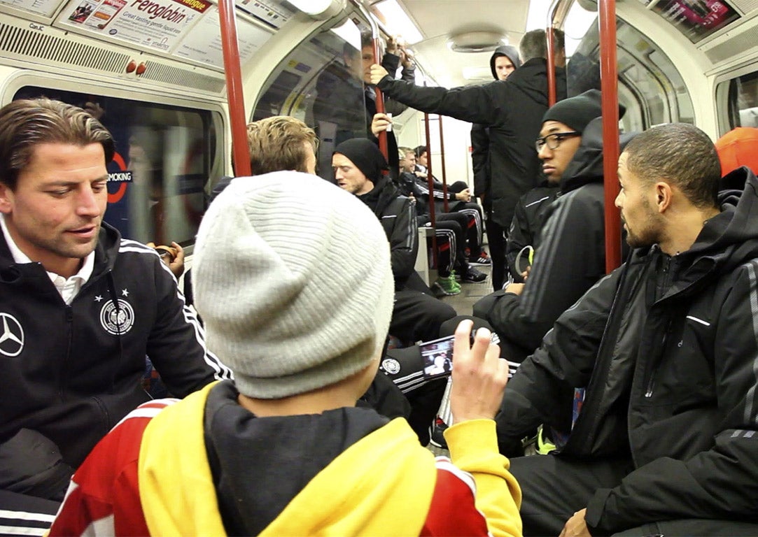 A child takes a picture of the Germany players as they ride the Tube