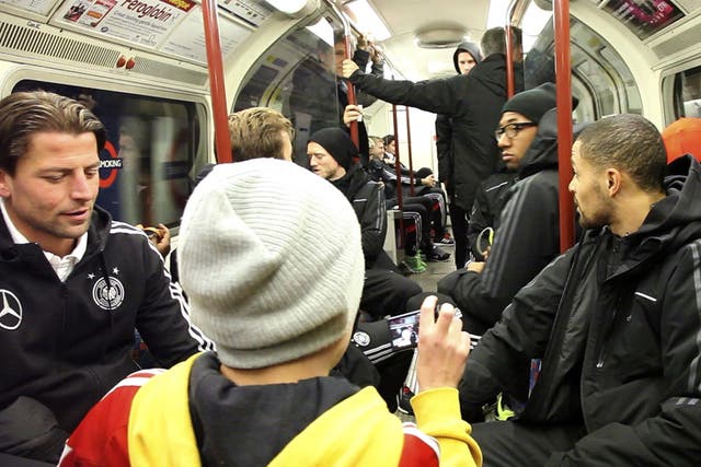 A child takes a picture of the Germany players as they ride the Tube