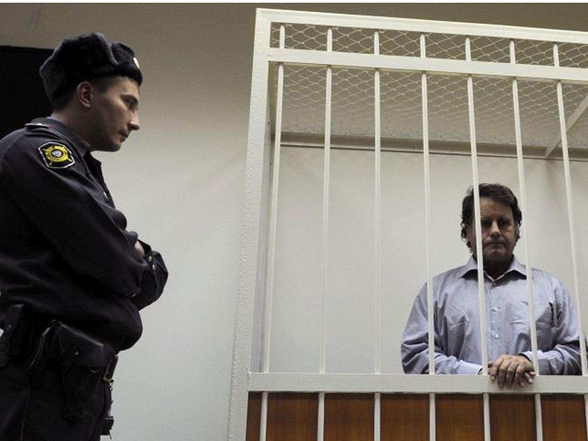 The captain of the Arctic Sunrise Dutch-flagged Greenpeace protest ship, Peter Willcox from USA, stands in a defendant cage in a court in Russia's second city of Saint Petersburg, on November 20, 2013.