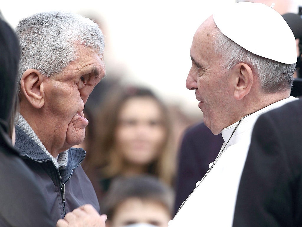 The Pope blesses a disfigured man in St. Peter's Square (Rex)