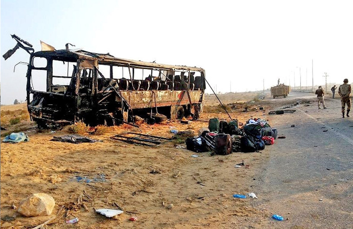 Egyptian military soldiers inspect the scene near the destroyed bus