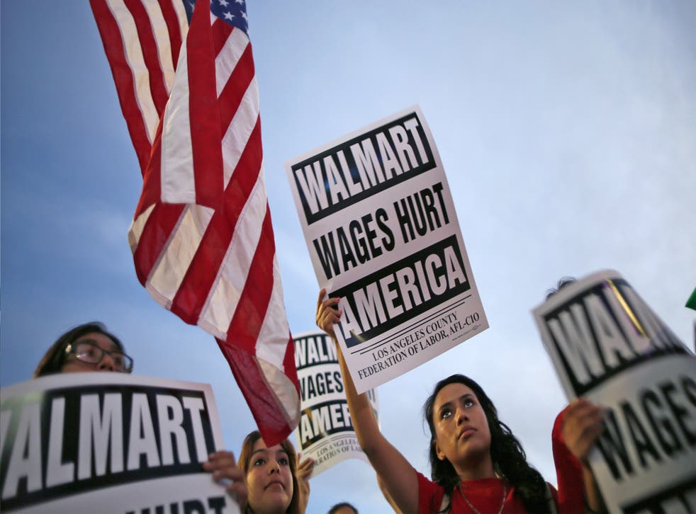 Karen Gariel (centre), 15, takes part in a protest for better wages outside Walmart in Los Angeles