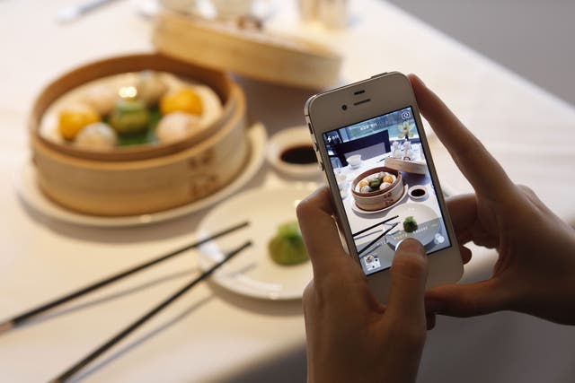 Food to share: diners take pictures of their meals at top restaurants to share on social media as a matter of course, as here at the Min Jiang restaurant, Royal Garden Hotel, in Kensington, London 