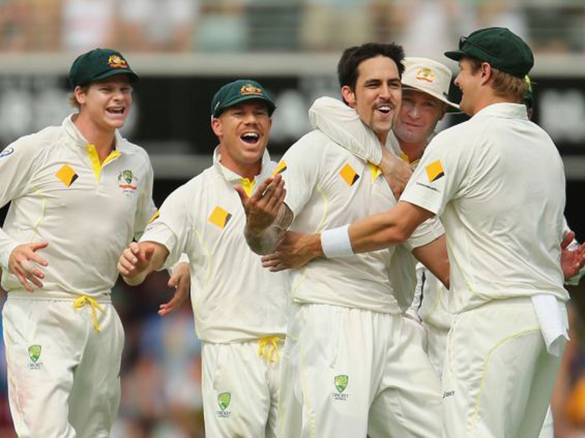 Mitchell Johnson celebrates with his team-mates after taking his fourth wicket