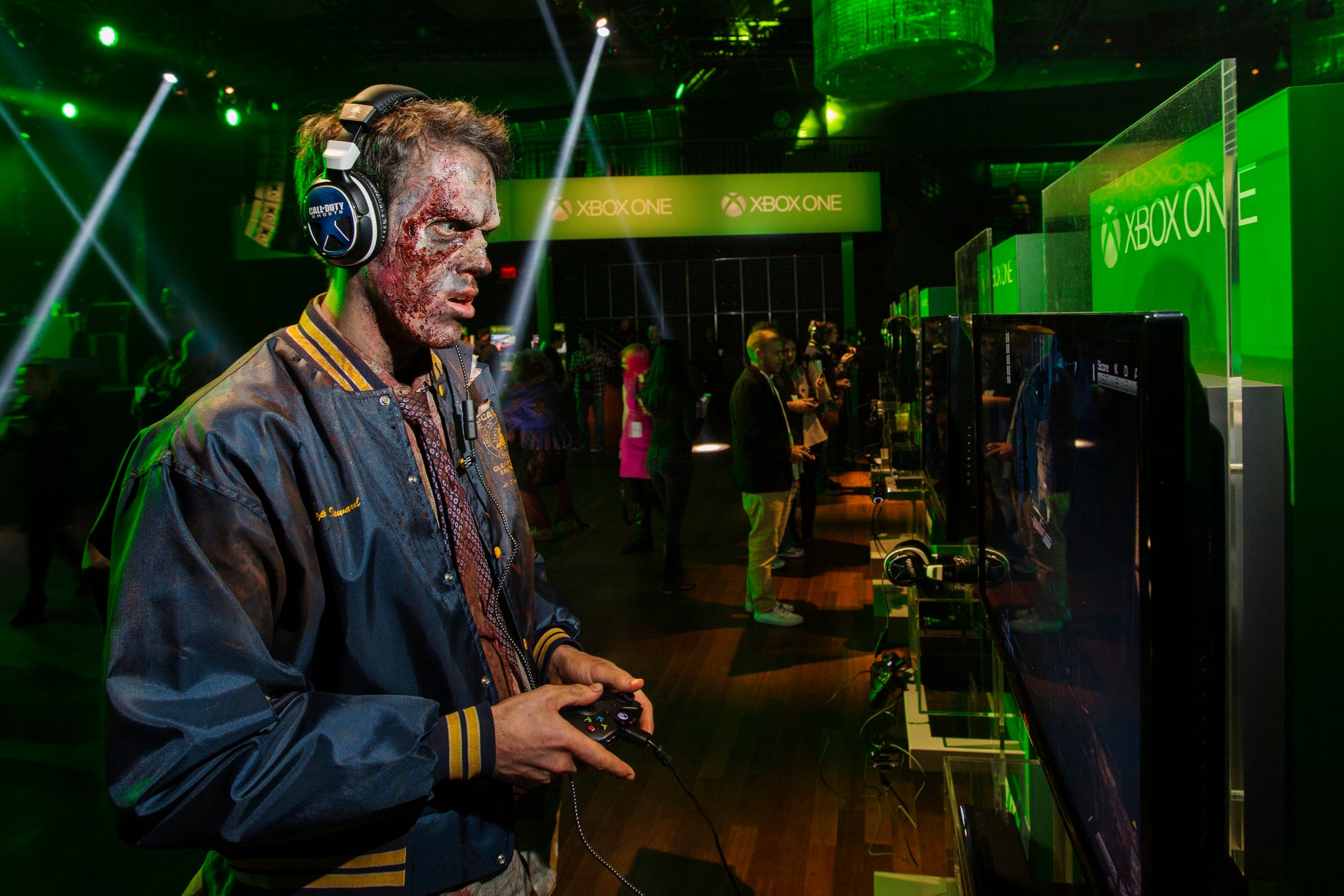 A man dressed as a zombie plays video games on an Xbox One console during a midnight launch event in New York.