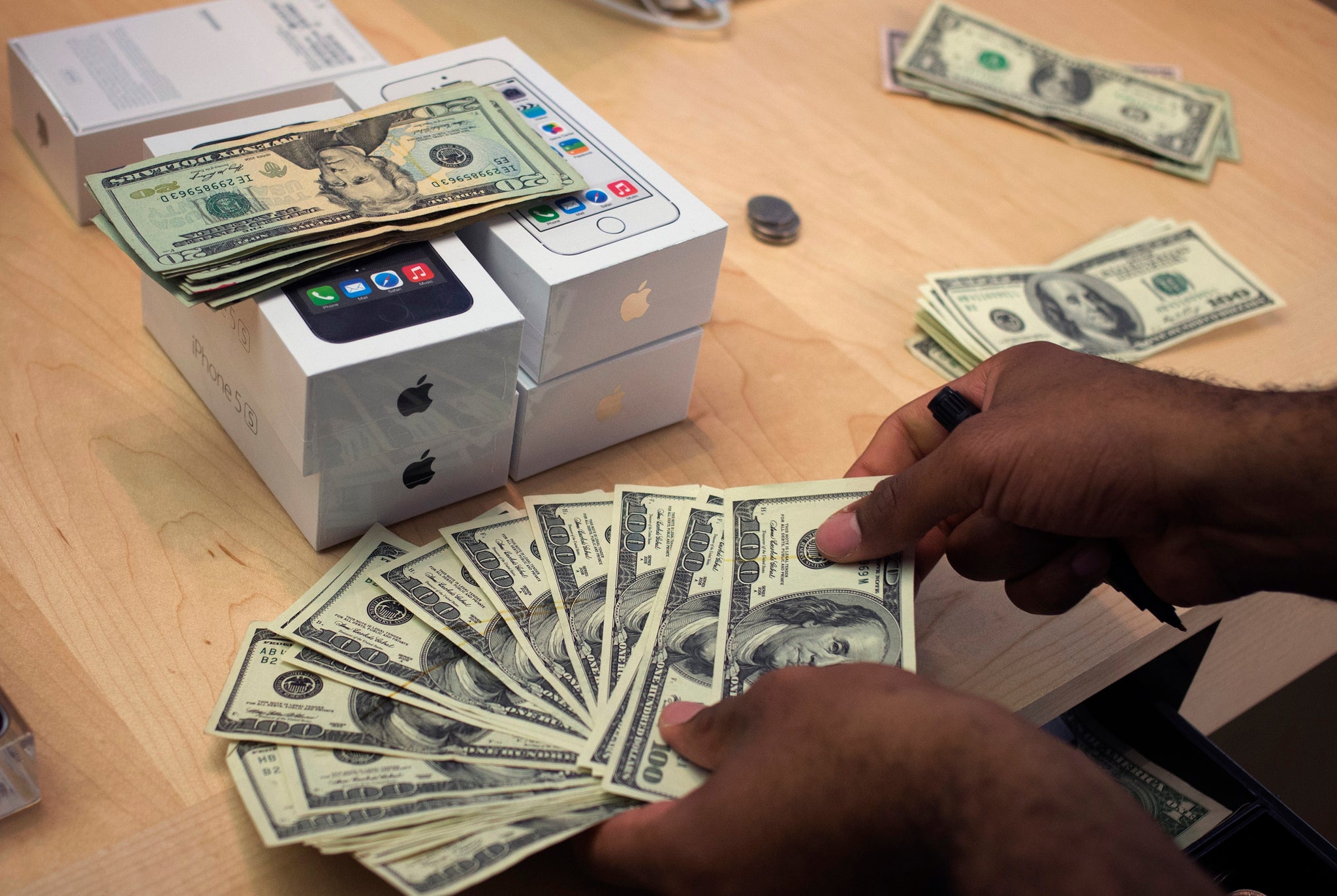 A cashier counts out currency in New York, handling sales of the iPhone 5s.