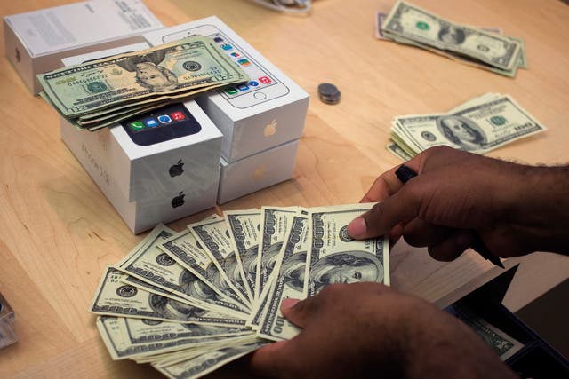 A cashier counts out currency in New York, handling sales of the iPhone 5s.
