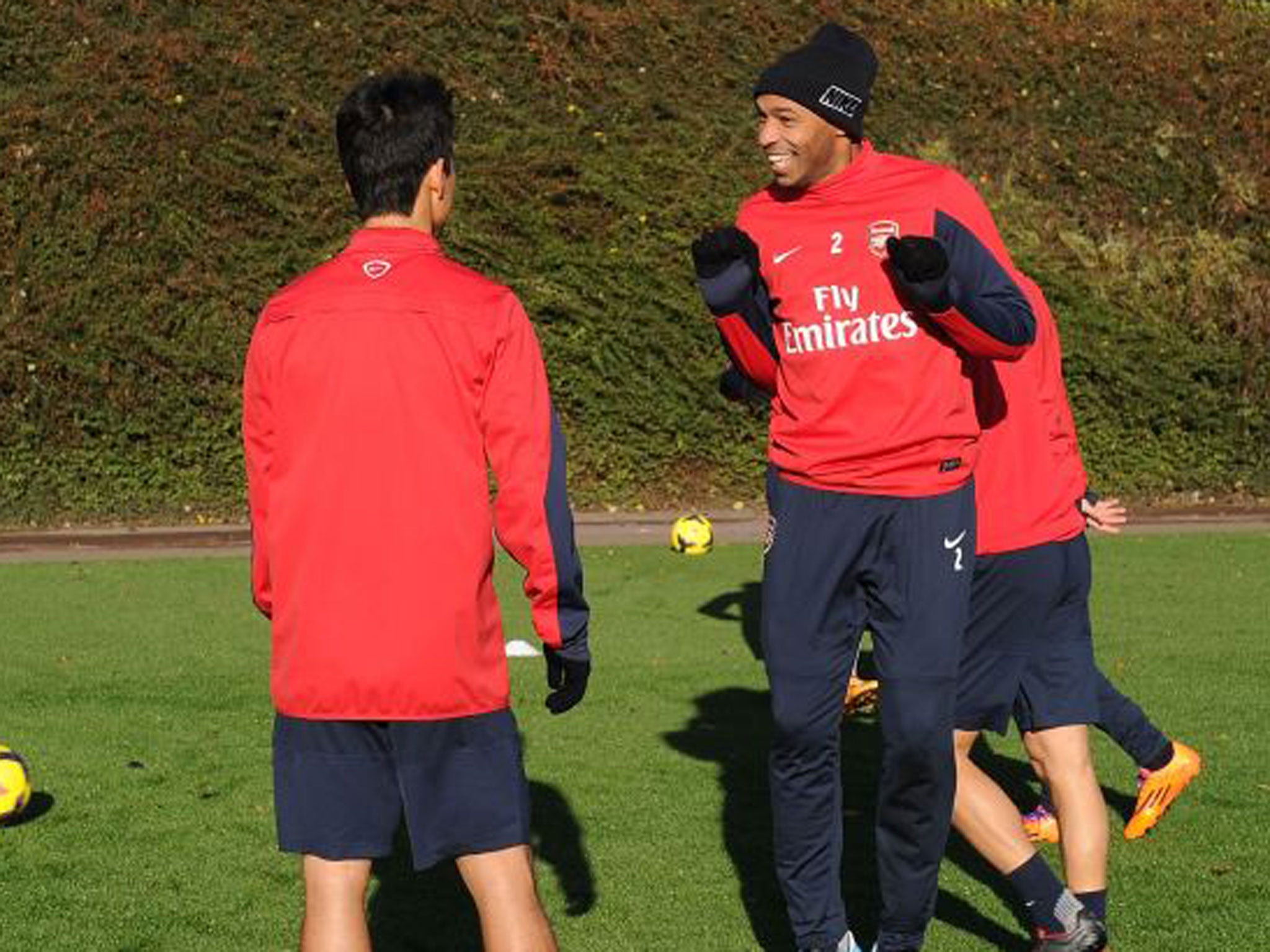 Thierry Henry talks to Mikel Arteta during training with Arsenal