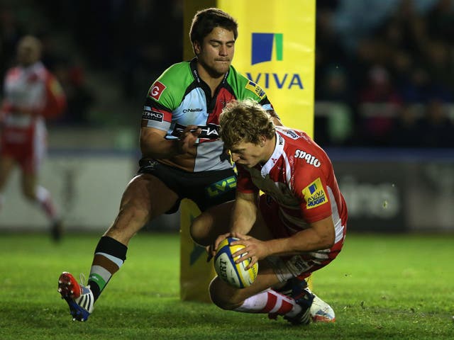 Billy Twelvetrees of Gloucester goes over for his try under pressure from Ben Botica