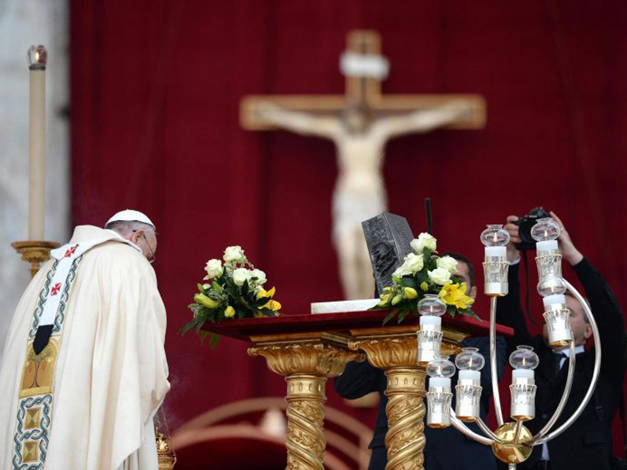 Pope Francis blesses the bronze reliquary containing the disputed bone fragments as a photographer catches the moment