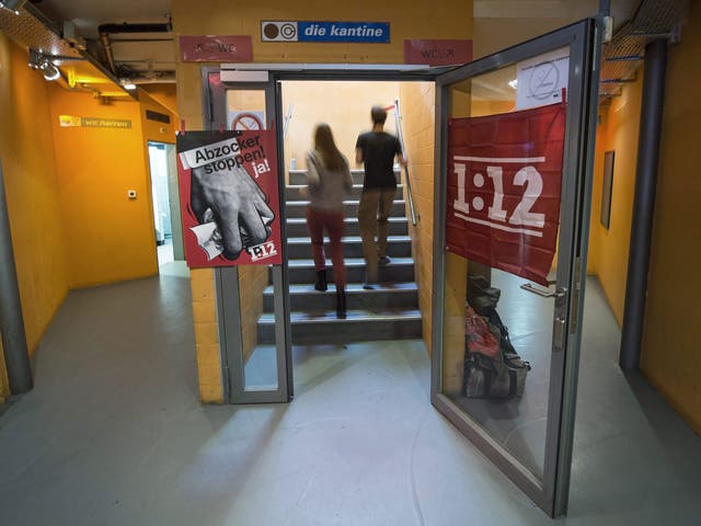 A poster reading '1:12' (R) hangs next to a poster with a slogan in German reading: 'Stop con atists - yes!'