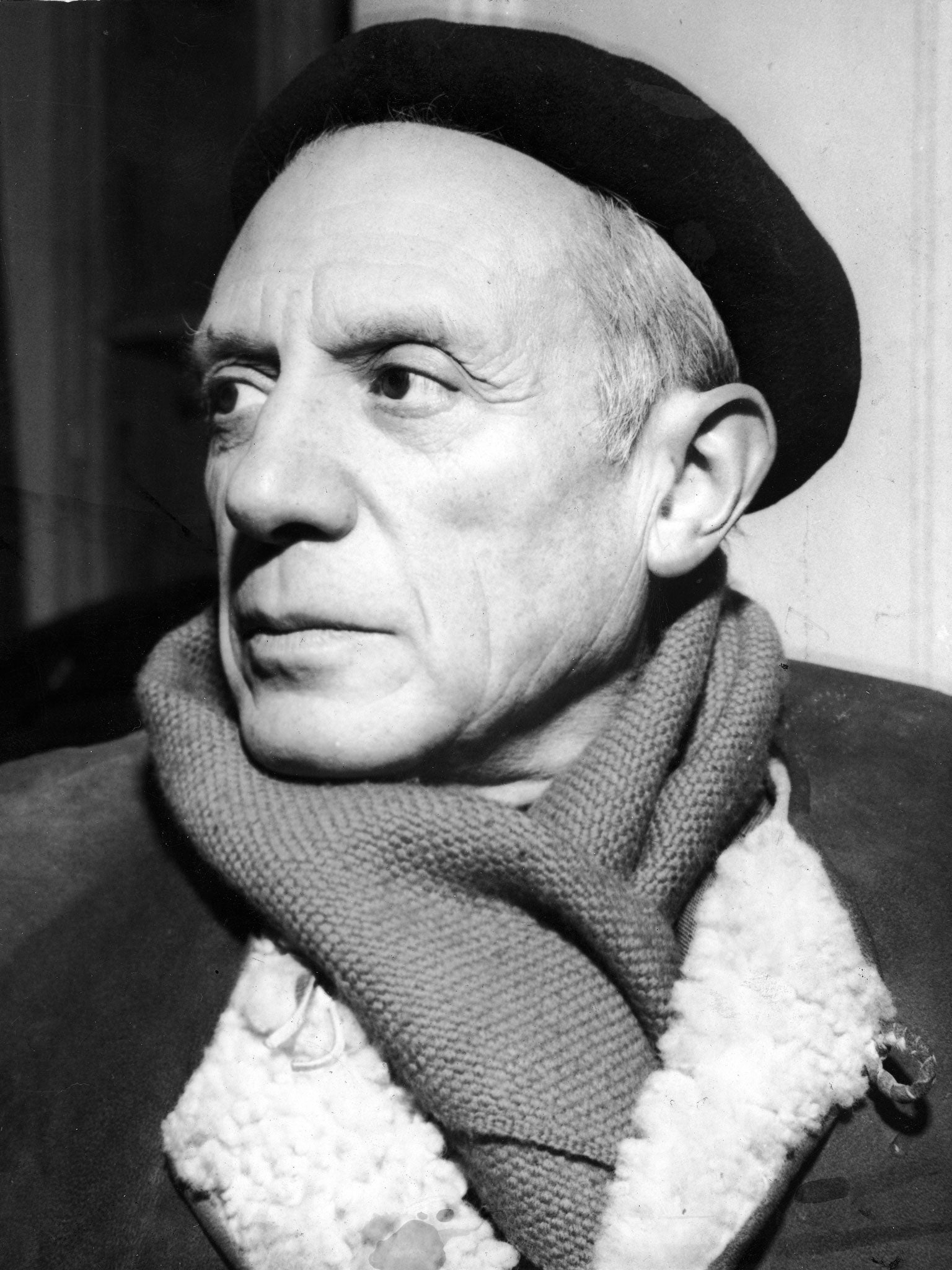 Portrait of Spanish-born artist Pablo Picasso (1881 - 1973) in a winter coat, scarf, and beret, 1950s