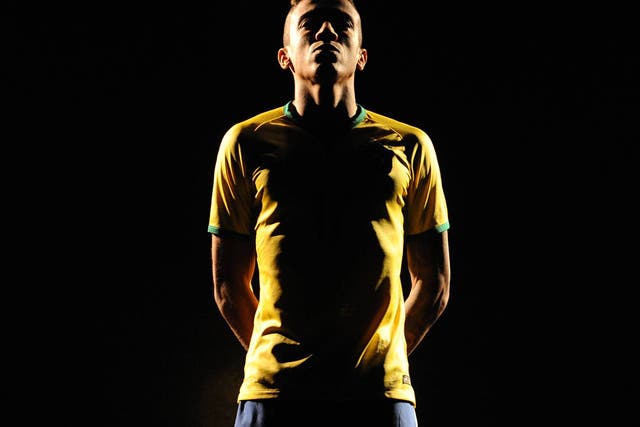 Brazil's Luiz Gustavo poses for pictures during the presentation of the new Brazil kit for the 2014 Fifa World Cup