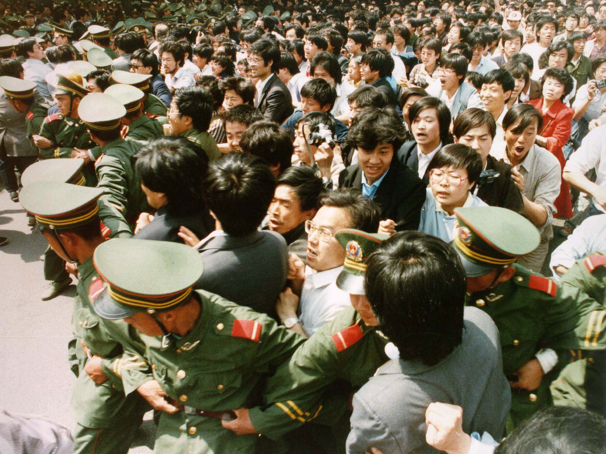 Crowds of jubilant students surge through a police cordon before pouring into Tiananmen Square on 4 June 1989.