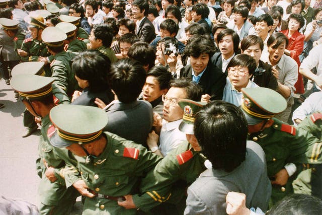 Crowds of jubilant students surge through a police cordon before pouring into Tiananmen Square on 4 June 1989.