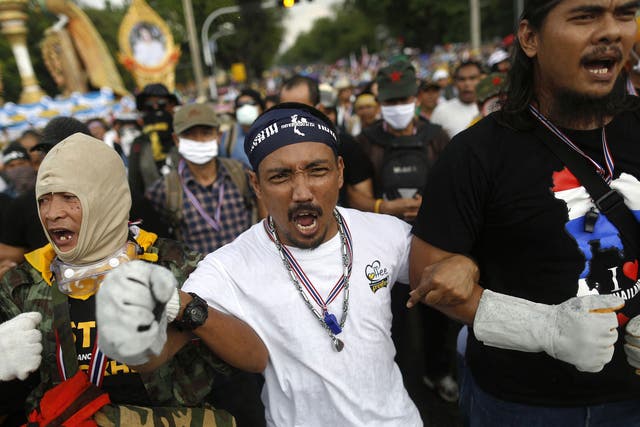 Protesters face a police barricade near the parliament buildings in Bangkok