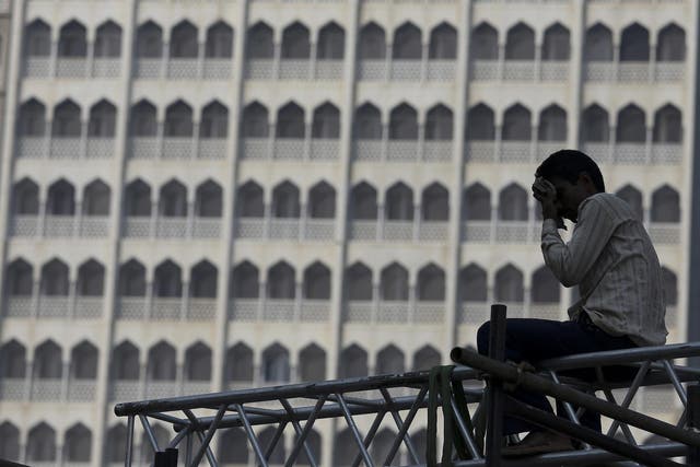 An Indian labourer erects a stage in front of the Taj Mahal hotel. Unskilled manual labourers are considered some of the country's most impoverished workers