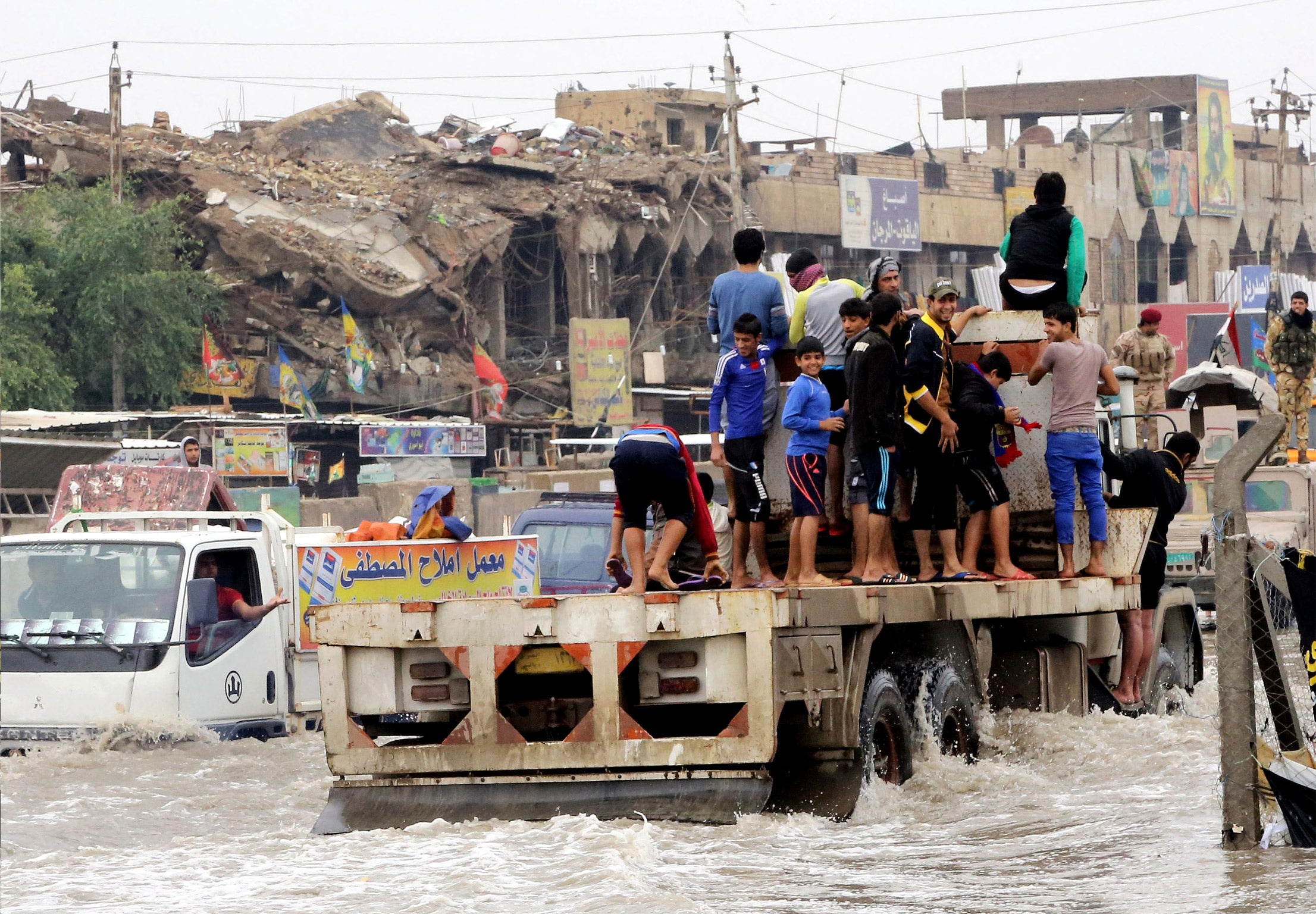 Iraqis make their way through the flooded streets of Baghdad after last week’s storm. Many people have criticised the response from central and provincial authorities