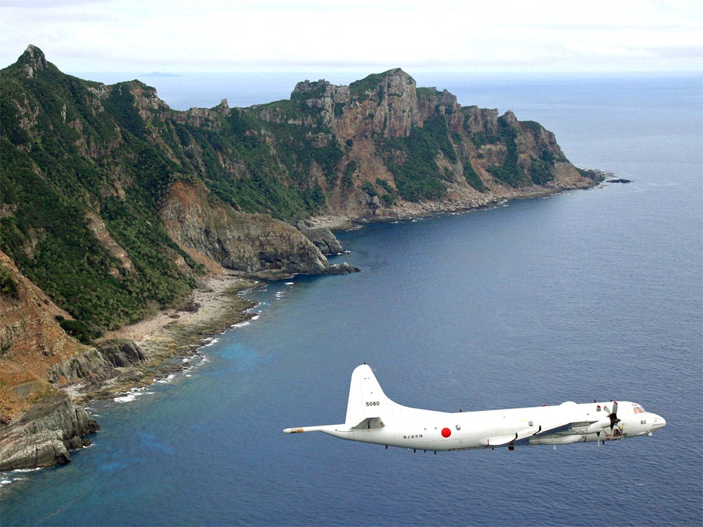 A Japanese surveillance plane flies over the disputed islands in the East China Sea, called the Senkaku in Japan and Diaoyu in China