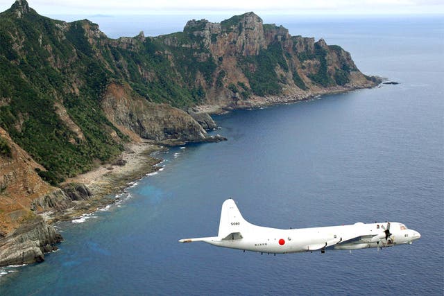 A Japanese surveillance plane flies over the disputed islands in the East China Sea, called the Senkaku in Japan and Diaoyu in China