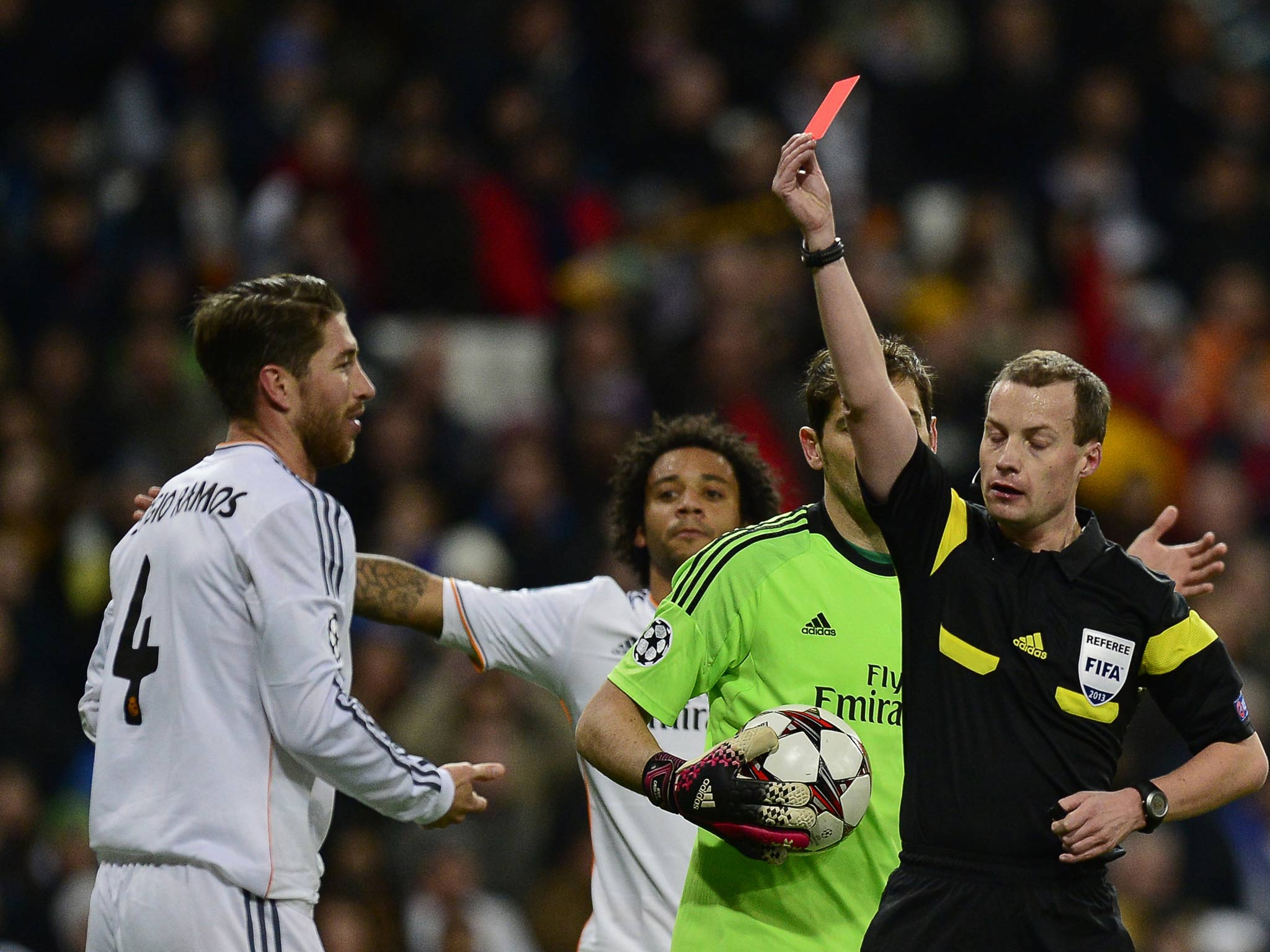 Referee shows a red card to Real Madrid's defender Sergio Ramos (L) during the UEFA Champions League football match Real Madrid CF vs Galatasaray SK at the Santiago Bernabeu