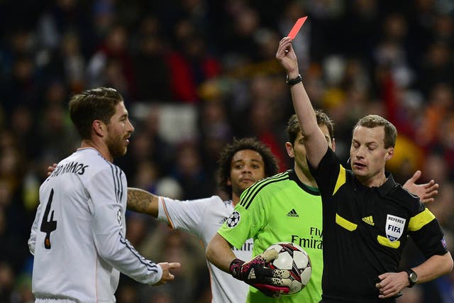 Referee shows a red card to Real Madrid's defender Sergio Ramos (L) during the UEFA Champions League football match Real Madrid CF vs Galatasaray SK at the Santiago Bernabeu