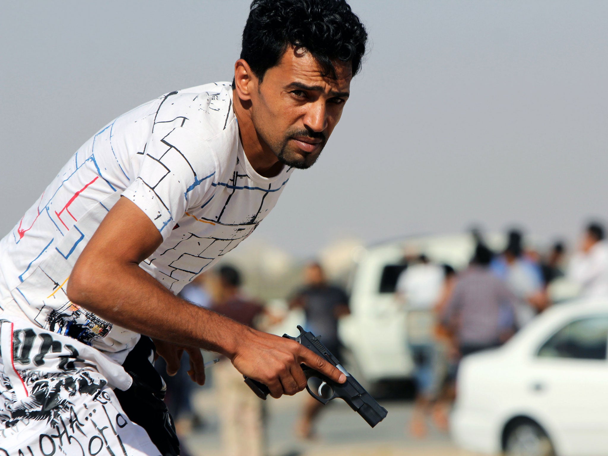 A Libyan protester holds a gun during clashes with troops in Benghazi