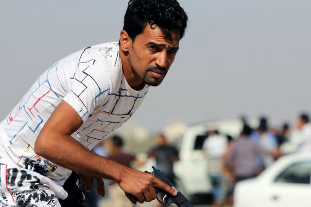 A Libyan protester holds a gun during clashes with troops in Benghazi