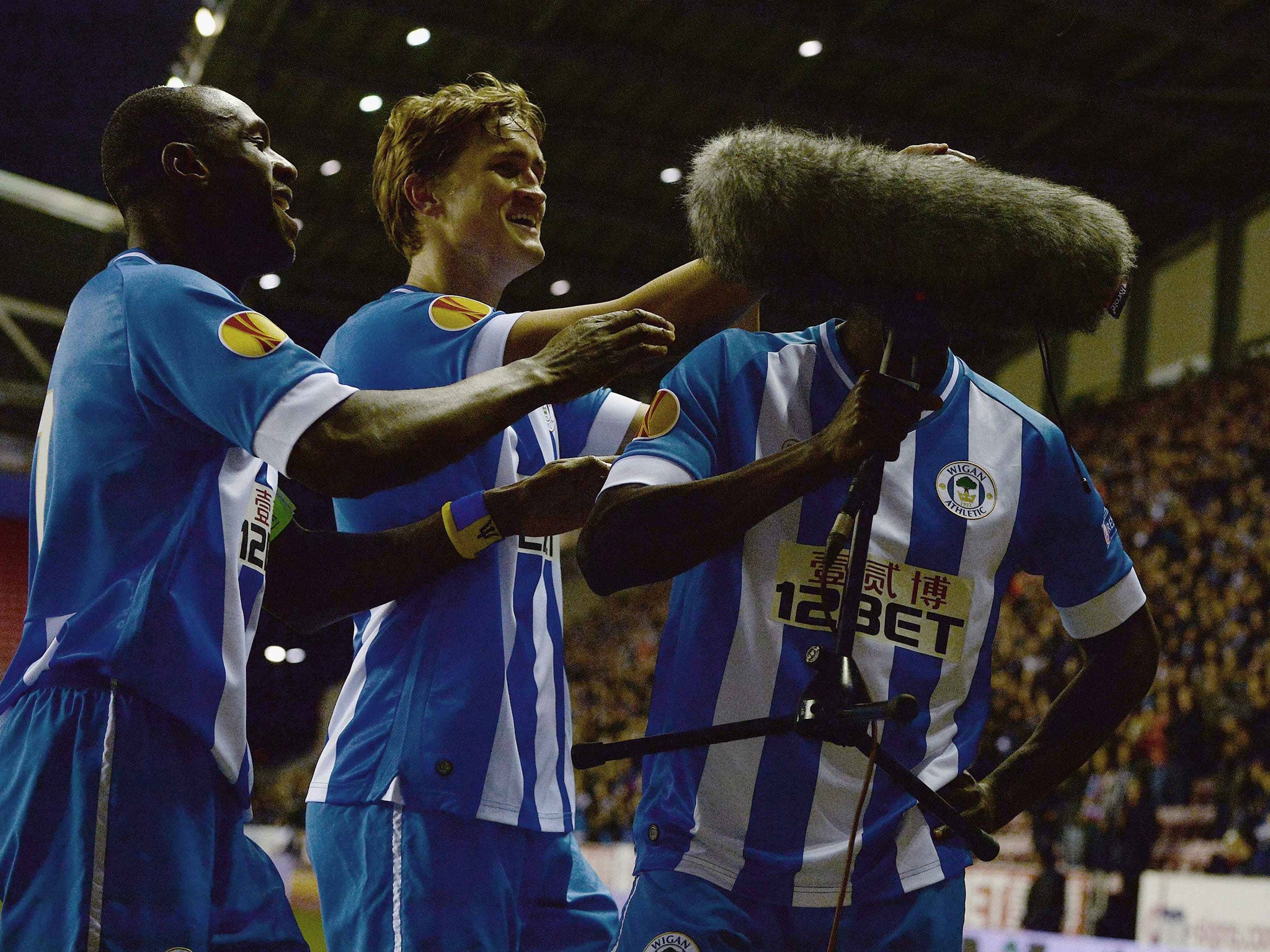 Leon Barnett celebrates scoring for Wigan by kissing a TV microphone