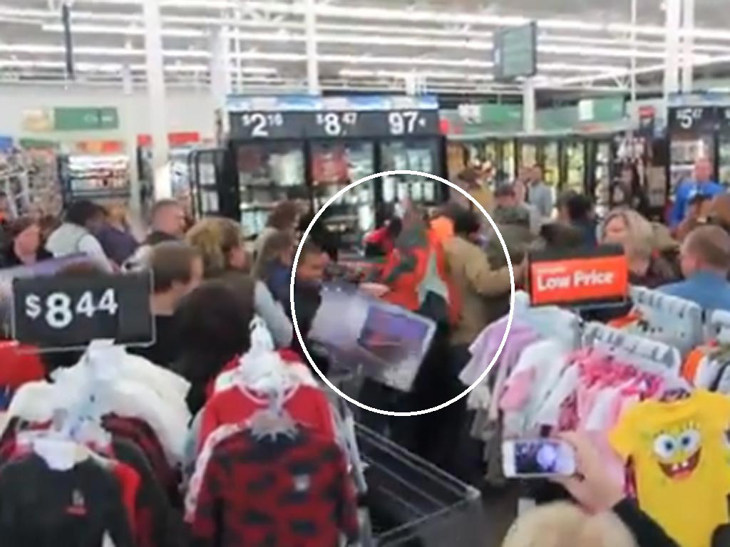 The man enters a knot of people and appears to fight over a television