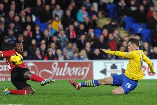 Aaron Ramsey slides in to score his second and Arsenal's third against Cardiff