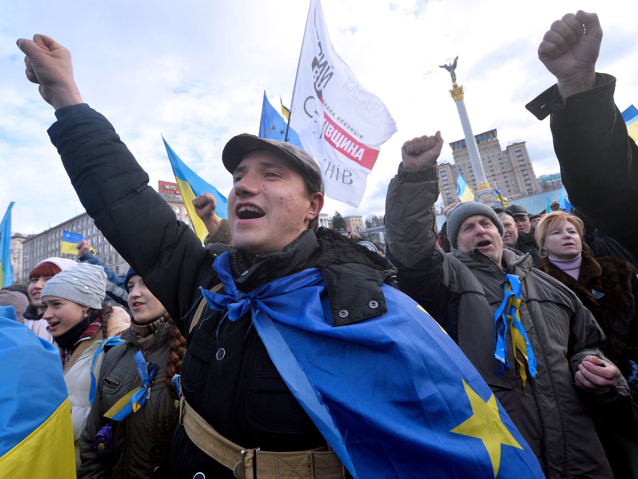People shout slogans and wave flags of Ukraine and the European Union during a rally of the opposition on Independence Square in Kiev