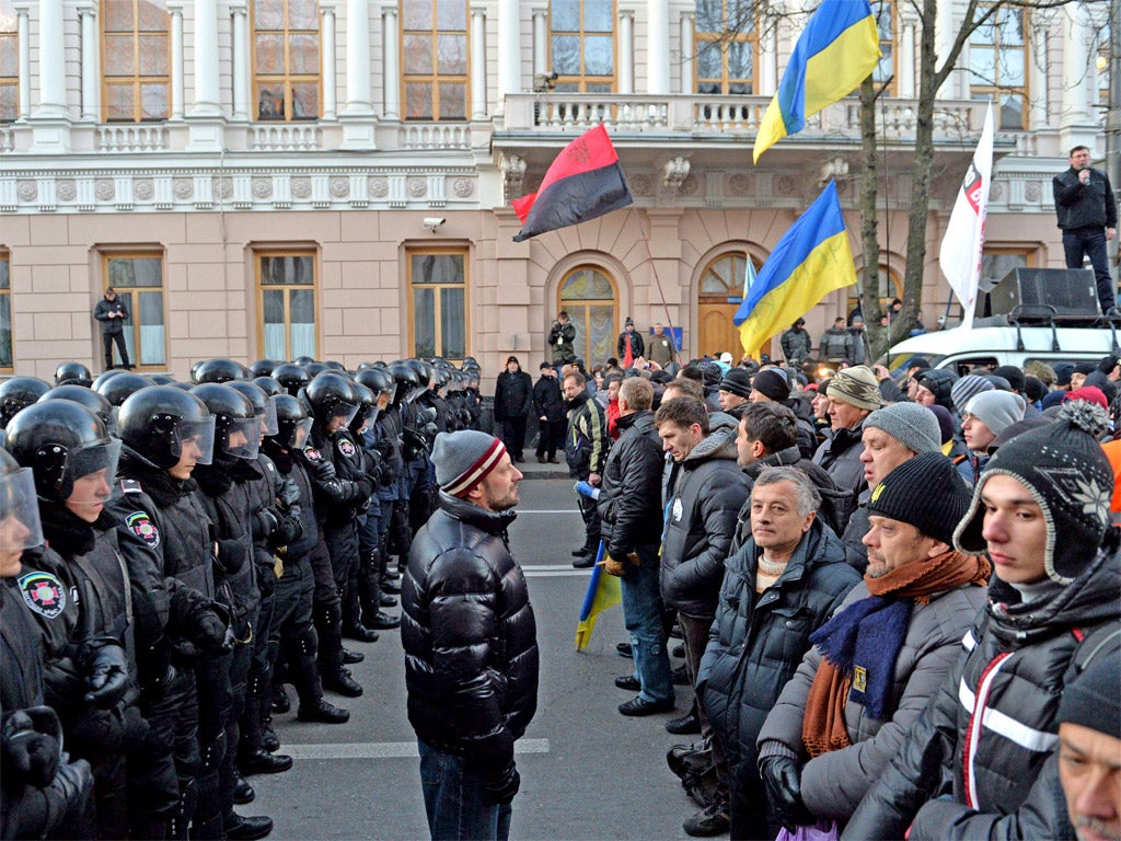 Protesters stand in front of riot policemen guarding the Ukrainian parliament in Kiev