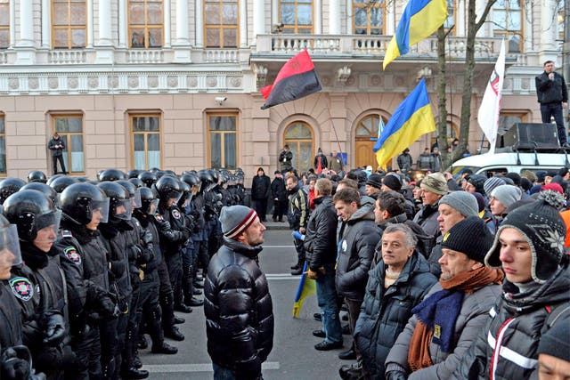 Protesters stand in front of riot policemen guarding the Ukrainian parliament in Kiev