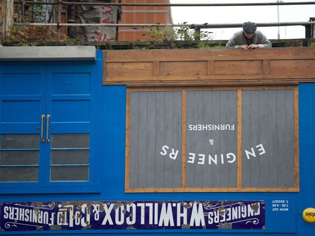 Artist  Alex Chinneck poses on the rooftop of his latest art installation 'Upside Down House', London