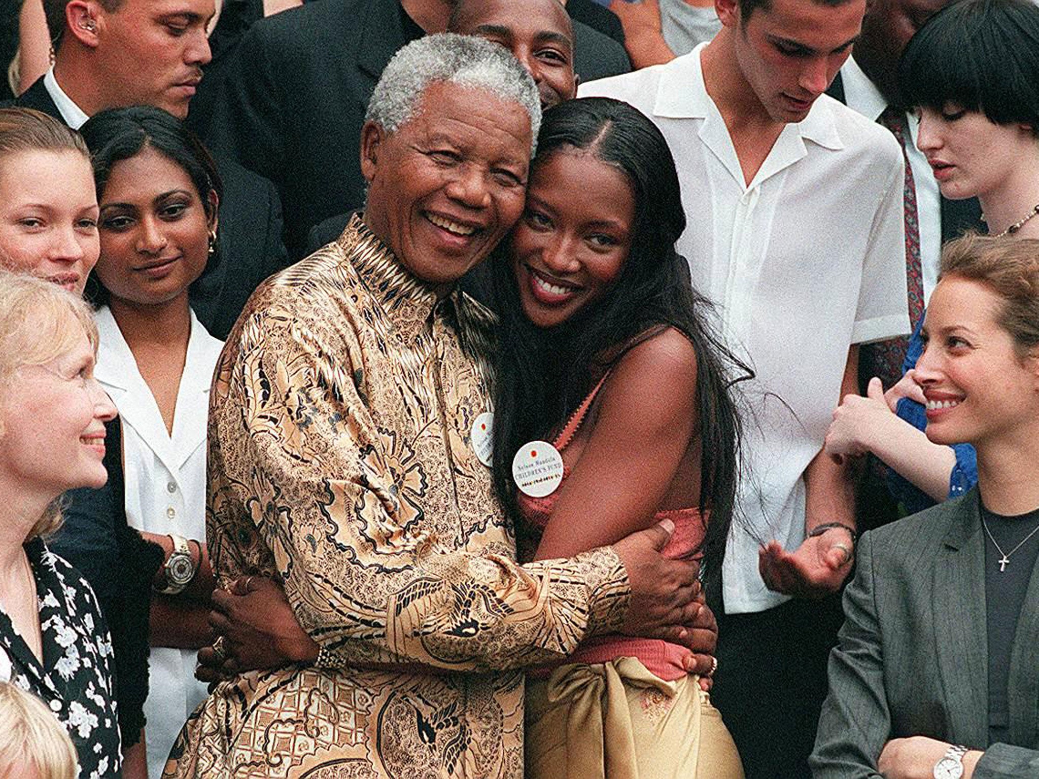 February 1998: Nelson Mandela (L) hugs British supermodel Naomi Campbell in front of American actress Mia Farrow, British model Kate Moss (second from left) and model Christy Turlington