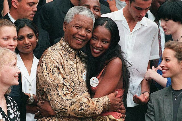 February 1998: Nelson Mandela (L) hugs British supermodel Naomi Campbell in front of American actress Mia Farrow, British model Kate Moss (second from left) and model Christy Turlington 